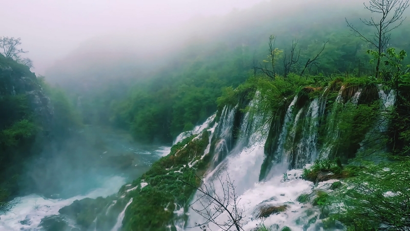 Waterfalls flowing through lush greenery and mist at Plitvice Lakes National Park in Croatia